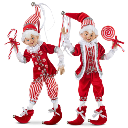 Two Christmas elves in red and white outfits with candy canes and lollipops on a white background.