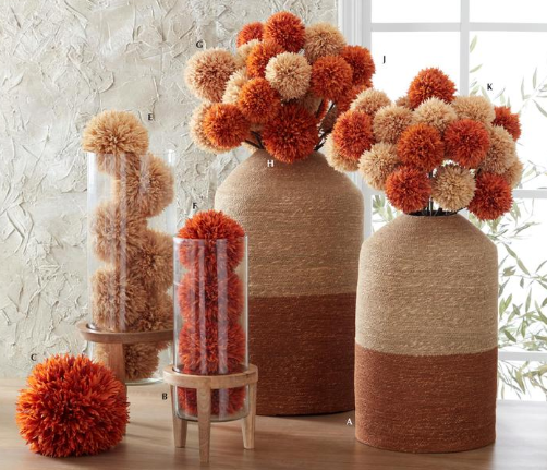 Decorative vases with pom-pom-like flowers on a neutral background