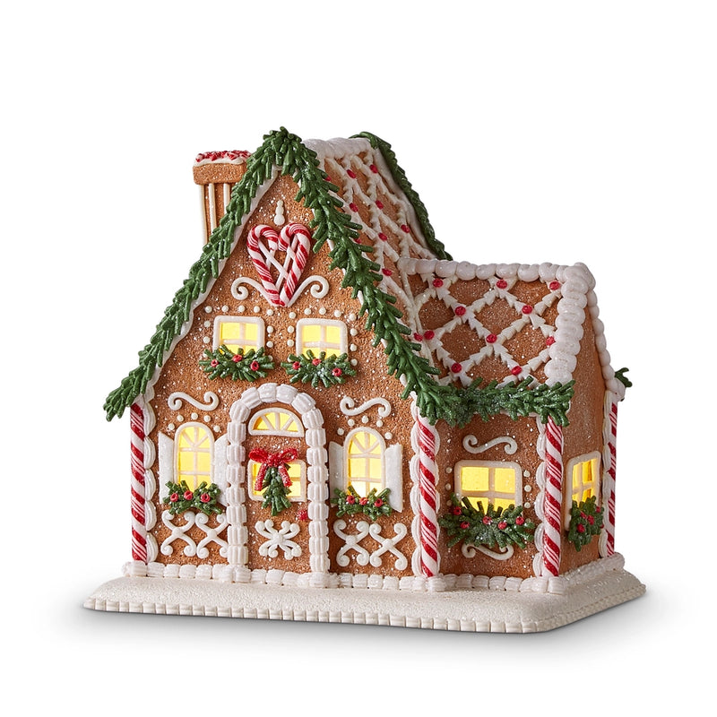 Decorative gingerbread house with candy cane details on a white background