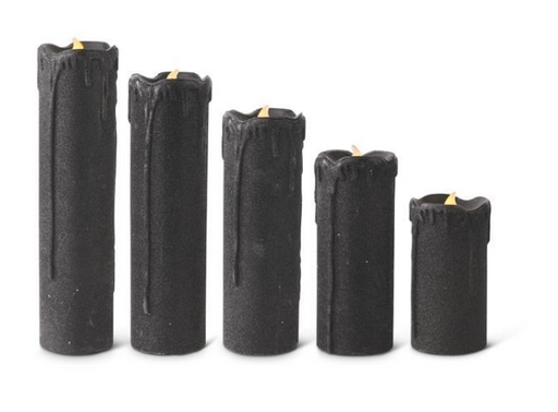 Set of five black candles of varying heights on a white background