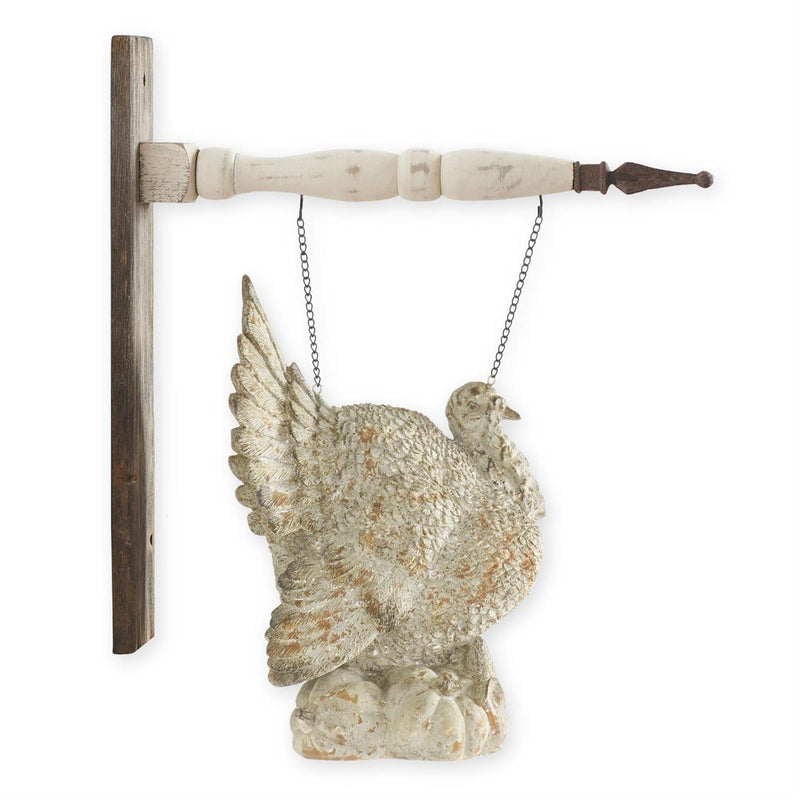 Decorative turkey figurine hanging on wall mounted arrow hanger