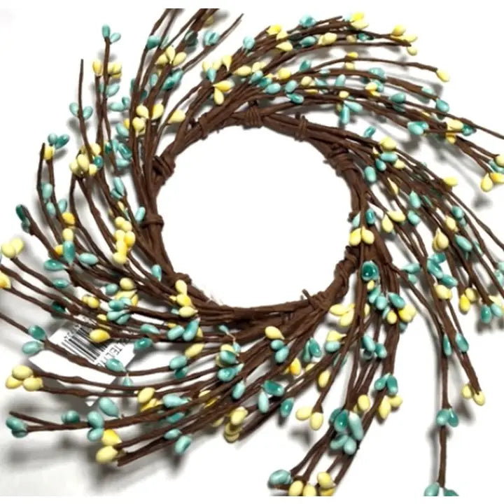 Decorative wreath with brown branches and small green and yellow berries on a white background