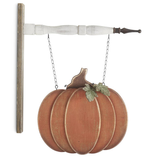 Decorative wall hanging with wooden pumpkins and a leaf on a white background