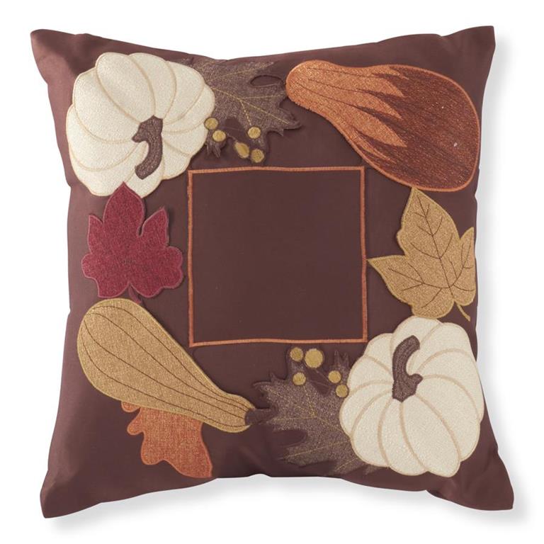 A square brown throw pillow featuring an autumn-themed applique design with embroidered pumpkins, gourds, leaves, and a central square frame.