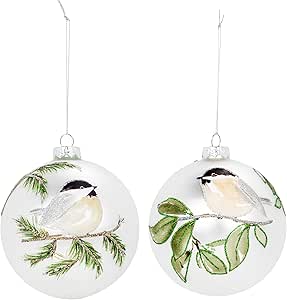 Two glass Christmas ornaments with birds and greenery on a white background