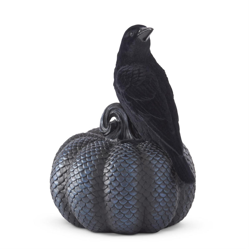 A black and metallic pumpkin with a velvet flocked crow statue on top.