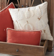 Decorative pillows with pumpkin pattern on a wooden surface