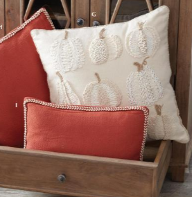 Decorative pillows with pumpkin pattern on a wooden surface