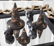 Halloween-themed decorations with black hats and skulls on a reflective surface.