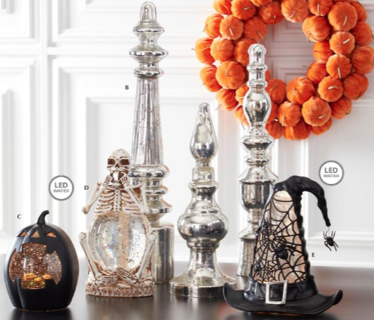 Halloween decorations including a wreath, pumpkins, and decorative items on a table.