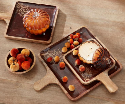 Wooden trays with decorative autumn-themed designs on a wooden surface