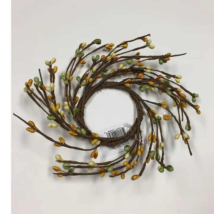 Decorative wreath with brown branches and small green and yellow leaves on a white background