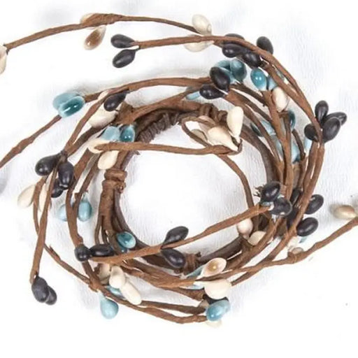 Coiled brown cord with black, blue, and white beads on a white background