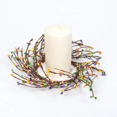 Decorative candle holder with branches and small colorful beads on a white background
