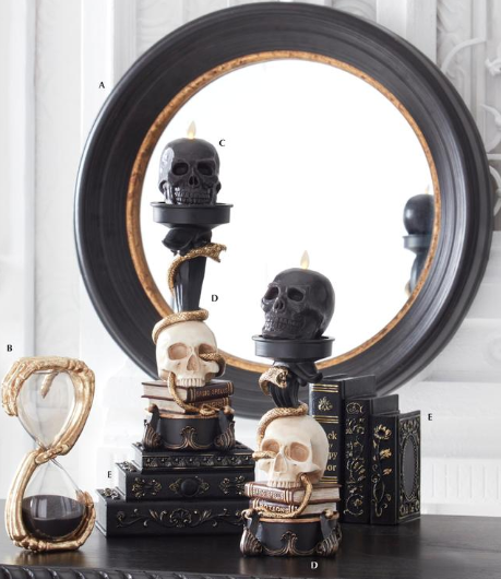Decorative skull-themed candle holders with a mirror in the background