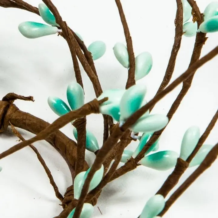 Artificial green leaves on brown branches against a white background