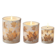 Three decorative candles with leaf patterns on a white background