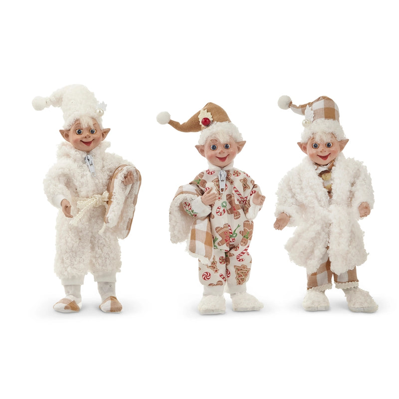 Three elf figurines in festive outfits on a white background