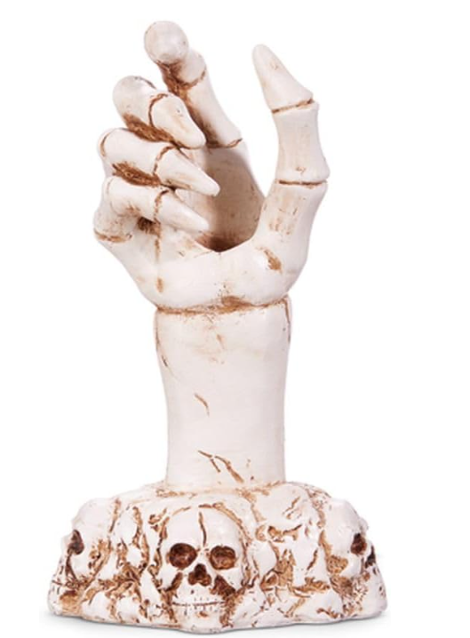 Decorative item with a hand reaching out from a skull on a white background
