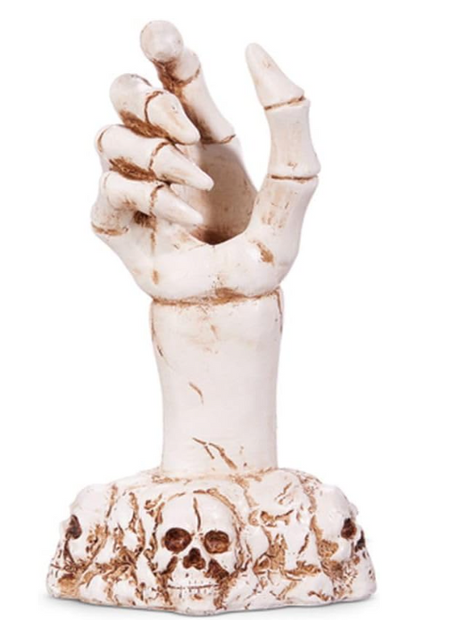 Decorative item with a hand reaching out from a skull on a white background