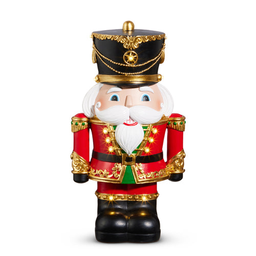 Decorative nutcracker figure with red outfit, black boots, and gold accents on a white background