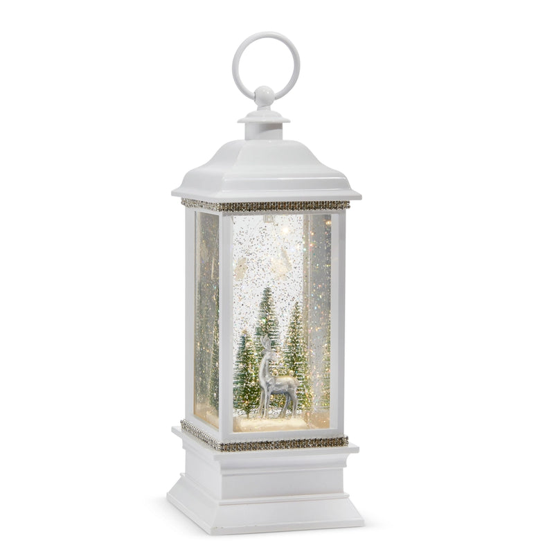 White lantern with a winter scene inside featuring trees and a deer on a white background