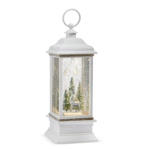 White lantern with a winter scene inside featuring trees and a deer on a white background