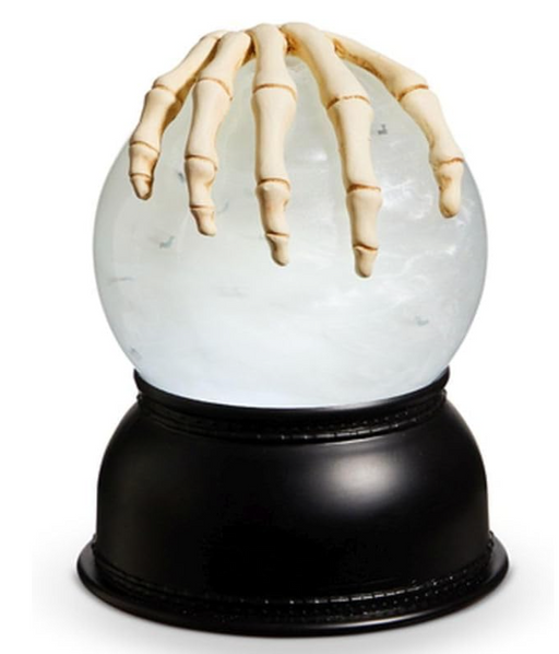 Glowing crystal ball with skeleton hand on a white background