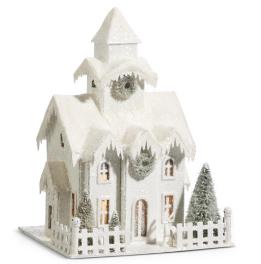 Decorative model of a snowy house with a clock tower on a white background