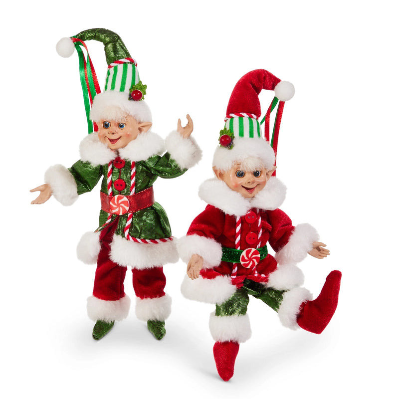 Two Christmas elves in red and green outfits with candy cane hats on a white background