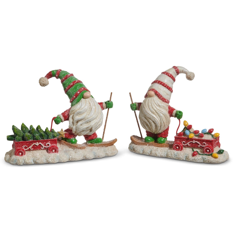 Two festive gnome figurines with skis and sleighs on a white background