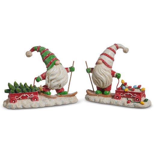 Two festive gnome figurines with skis and sleighs on a white background