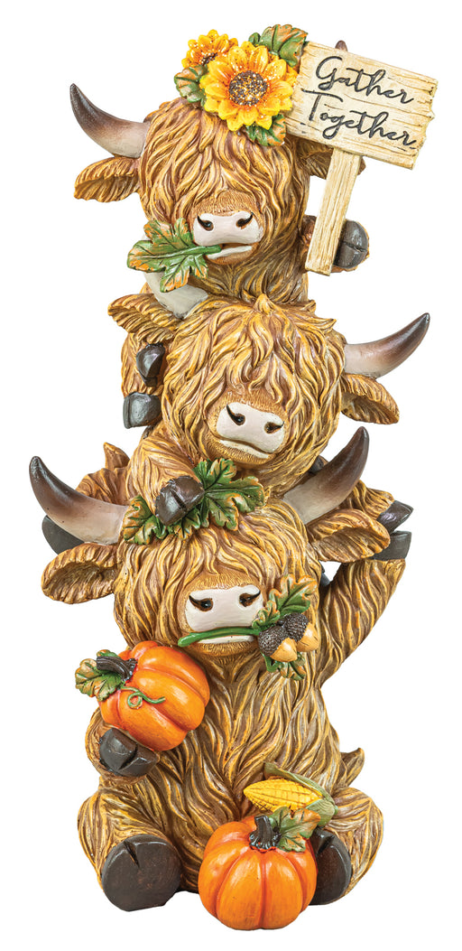 A stacked set of three Highland cow figurines decorated for autumn, featuring sunflowers, pumpkins, corn, and a wooden sign that reads 'Gather Together'.