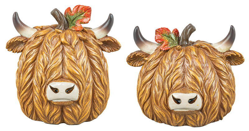 Two decorative Highland cow figurines with long shaggy brown fur, curved horns, and small red-orange leaves on top, shown side by side on a plain white background.