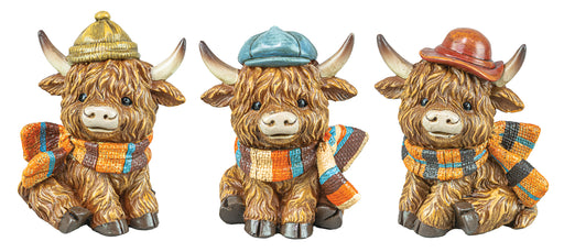 Three Highland cow figurines wearing hats and scarves on a white background