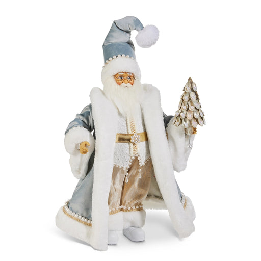 Decorative figure of a Santa Claus-like character in a white and blue outfit with a hat, holding a small tree on a white background.