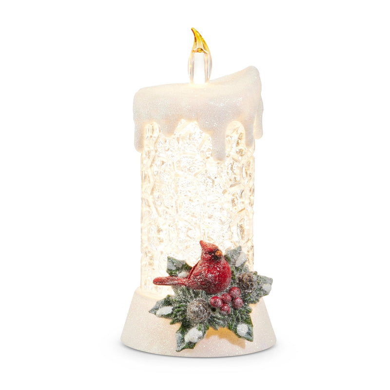 Decorative candle with a red cardinal and winter scene on a white background