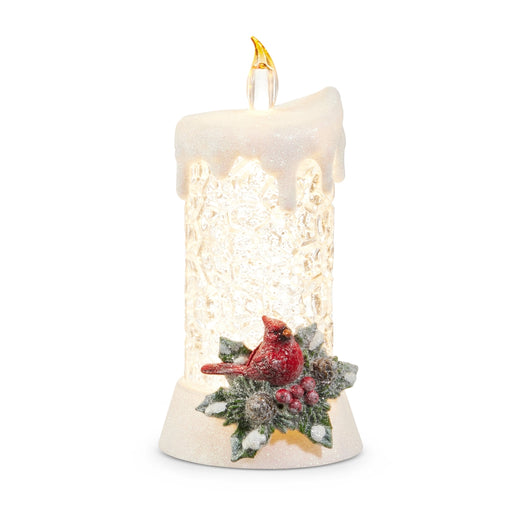 Decorative candle with a red cardinal and winter scene on a white background