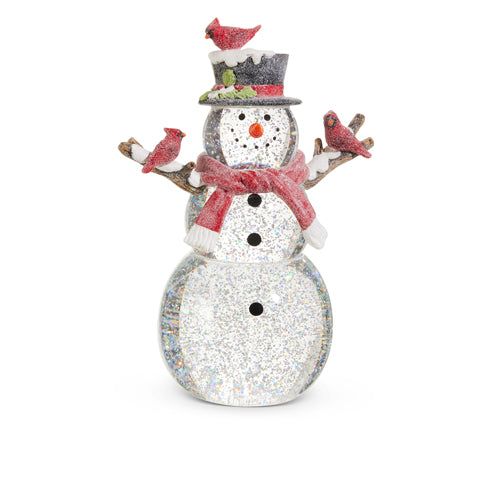 A lighted snowman figurine with silver glitter and a silver lantern, adorned with red birds on its hat and scarf.