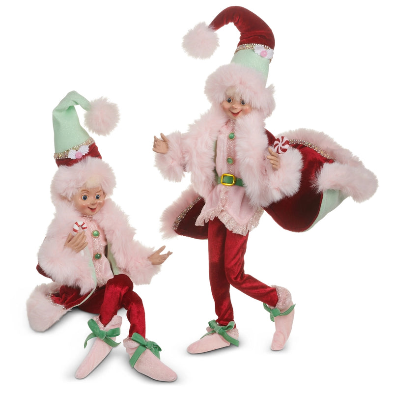 Two Christmas-themed dolls in festive outfits with red, green, and white colors on a white background.