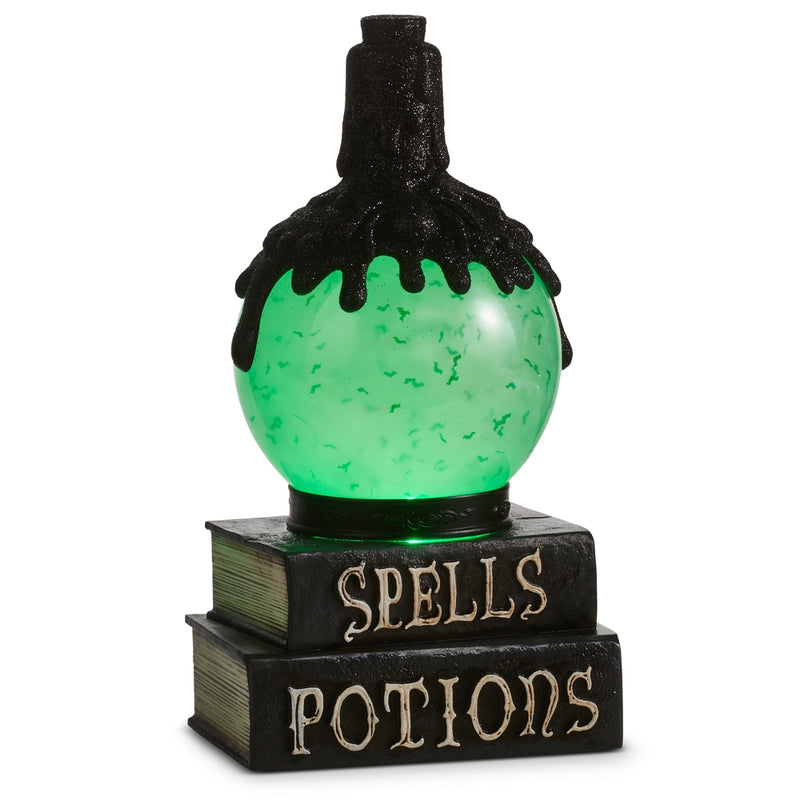 Decorative potion bottle with green liquid on a book titled 'Spells Potions' against a white background