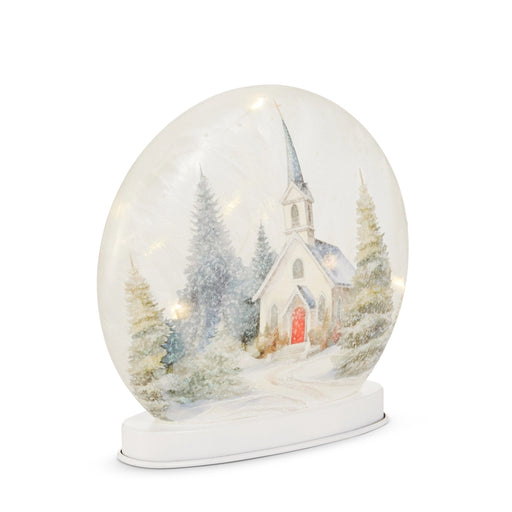 Snow globe with a church and trees inside on a white background