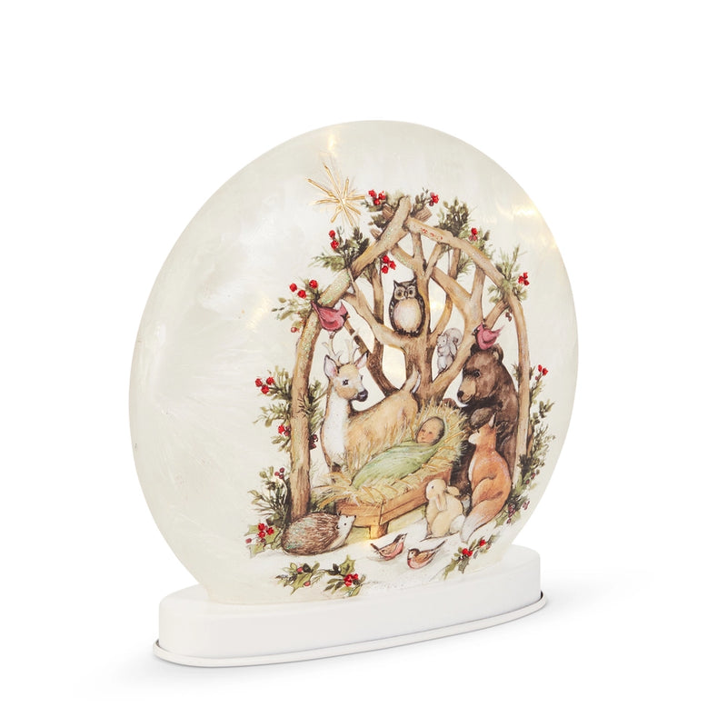 Decorative snow globe with a nativity scene featuring animals in a forest setting.