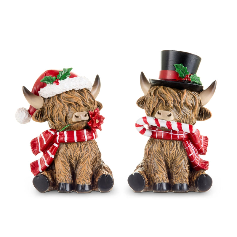 Two decorative Highland cow figurines wearing Christmas hats and scarves on a white background.