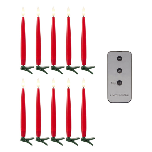 Set of red candles with green holders and a remote control on a white background