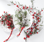 Decorative branches with red berries and green leaves on a white background