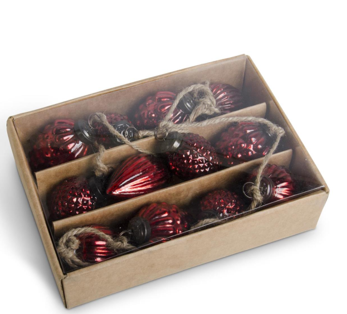 Box of red glass ornaments with twine on a white background