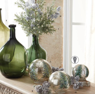 Decorative glass vases and mirrored ornaments arranged on a windowsill with dried flowers and pinecones. The set includes a large dark green glass bottle, a tall green glass vase with floral stems, and three round mirrored ornaments with a green tree pattern.