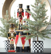 Decorative nutcrackers with a Christmas tree and checkered pots on a white background