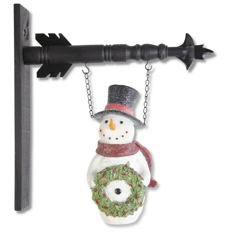 Decorative snowman with a wreath hanging from a black metal bracket on a white background